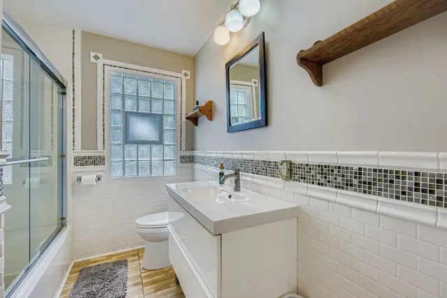 a bathroom with a sink a toilet and shower