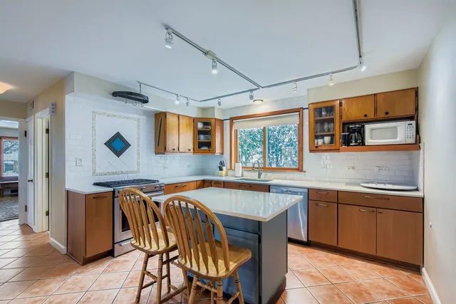 a dining hall with stainless steel appliances granite countertop a sink and a refrigerator