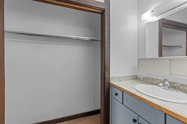 a view of a kitchen with refrigerator and white cabinets