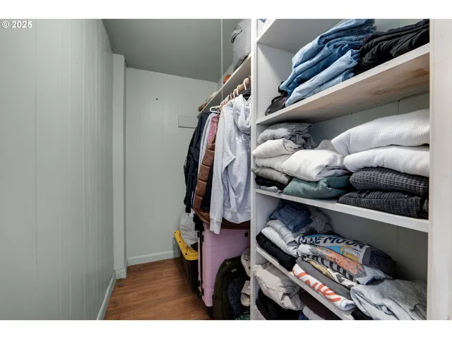 a view of walk in closet with clothes and shoes
