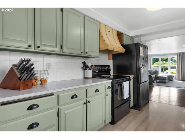 a kitchen with stainless steel appliances granite countertop a sink a stove and a refrigerator