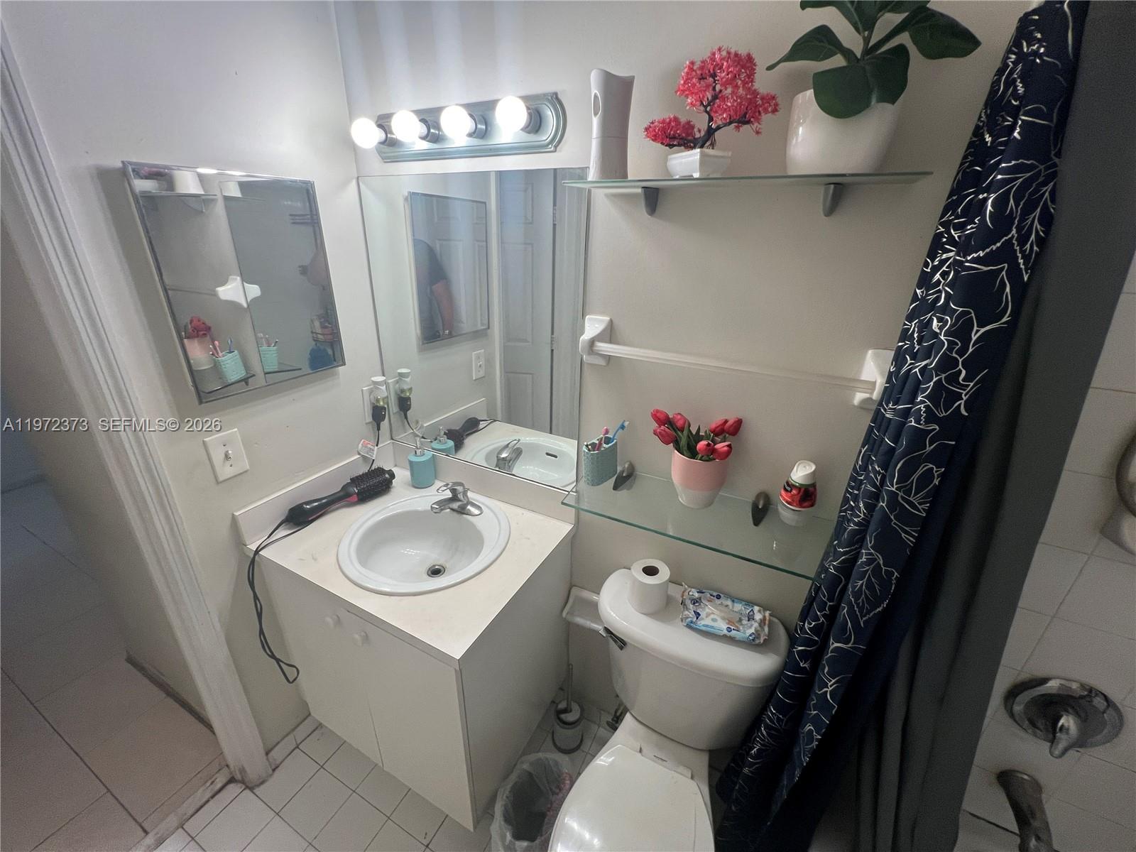 45 Southwest 14th Terrace Homestead, FL 33030 - Photo 38 of 40 a bathroom with a toilet sink and mirror