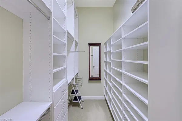 a view of walk in closet with empty racks