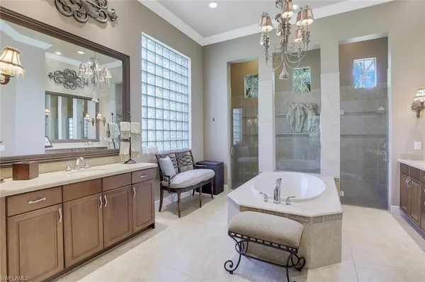 a spacious bathroom with a tub sink and mirror
