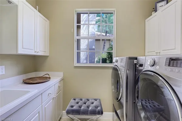 a utility room with sink dryer and washer