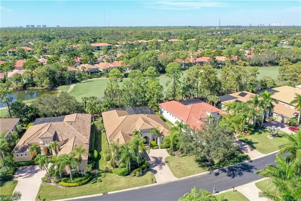 an aerial view of residential houses with outdoor space and trees