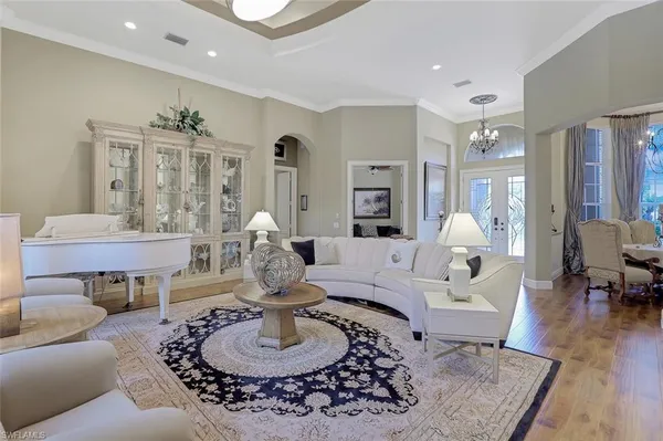 a living room with furniture couches and a dining table with wooden floor