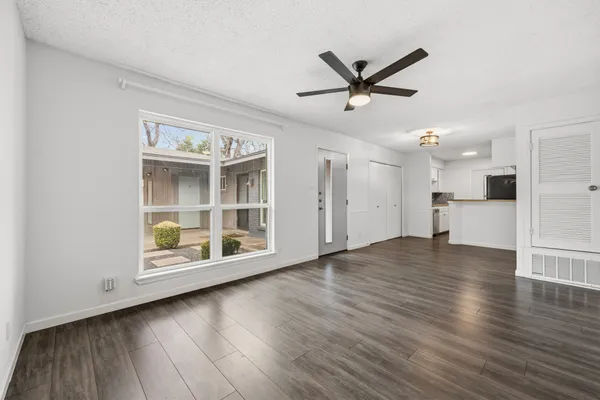 a view of a kitchen with wooden floor and a ceiling fan