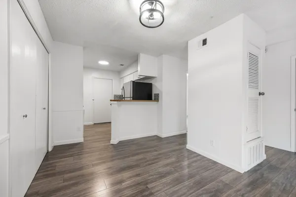 a view of a kitchen with wooden floor and a refrigerator