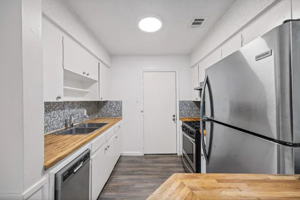 a kitchen with a refrigerator and a sink