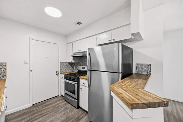 a kitchen with a refrigerator and a stove