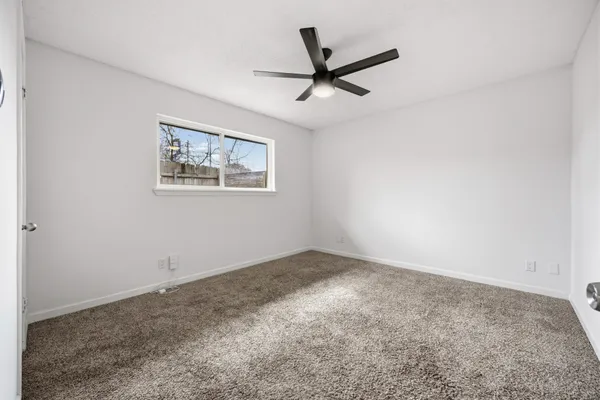 a view of a big room with wooden floor and a ceiling fan
