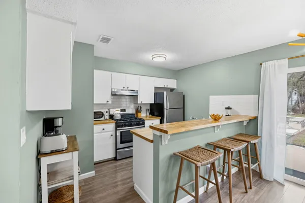 a kitchen with refrigerator cabinets and wooden floor