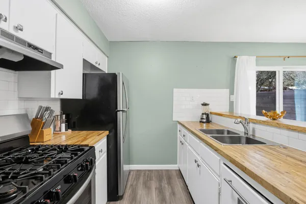 a kitchen with stainless steel appliances a sink stove and refrigerator