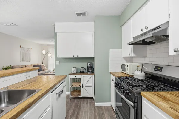 a kitchen with stainless steel appliances a sink stove and cabinets