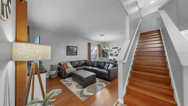 a living room with furniture and a wooden floor