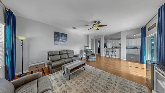 a living room with furniture and view of kitchen