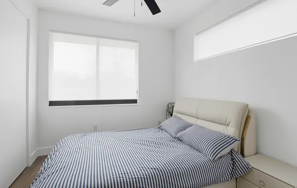 a bedroom with a bed and a window