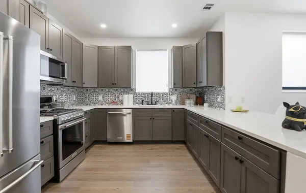 a kitchen with stainless steel appliances granite countertop a sink and stove top oven