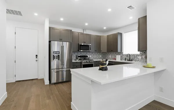 a kitchen with stainless steel appliances a refrigerator sink and microwave