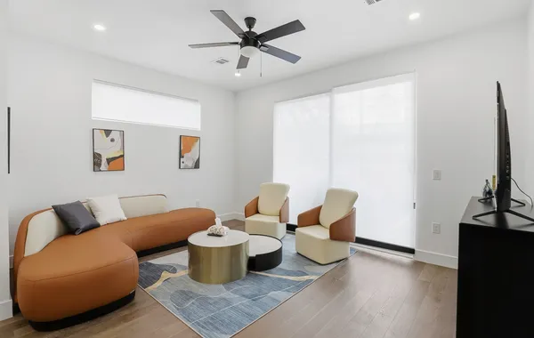 a living room with furniture a rug and a flat screen tv