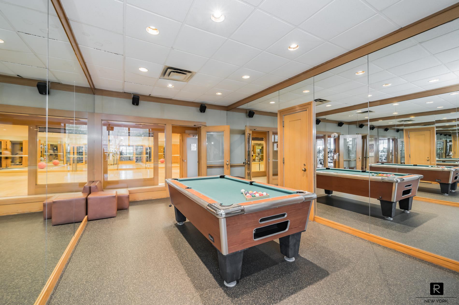 415 East 37th Street, Unit 27D Manhattan, NY 10016 - Photo 14 of 17 a living room with stainless steel furniture pool table and a large window