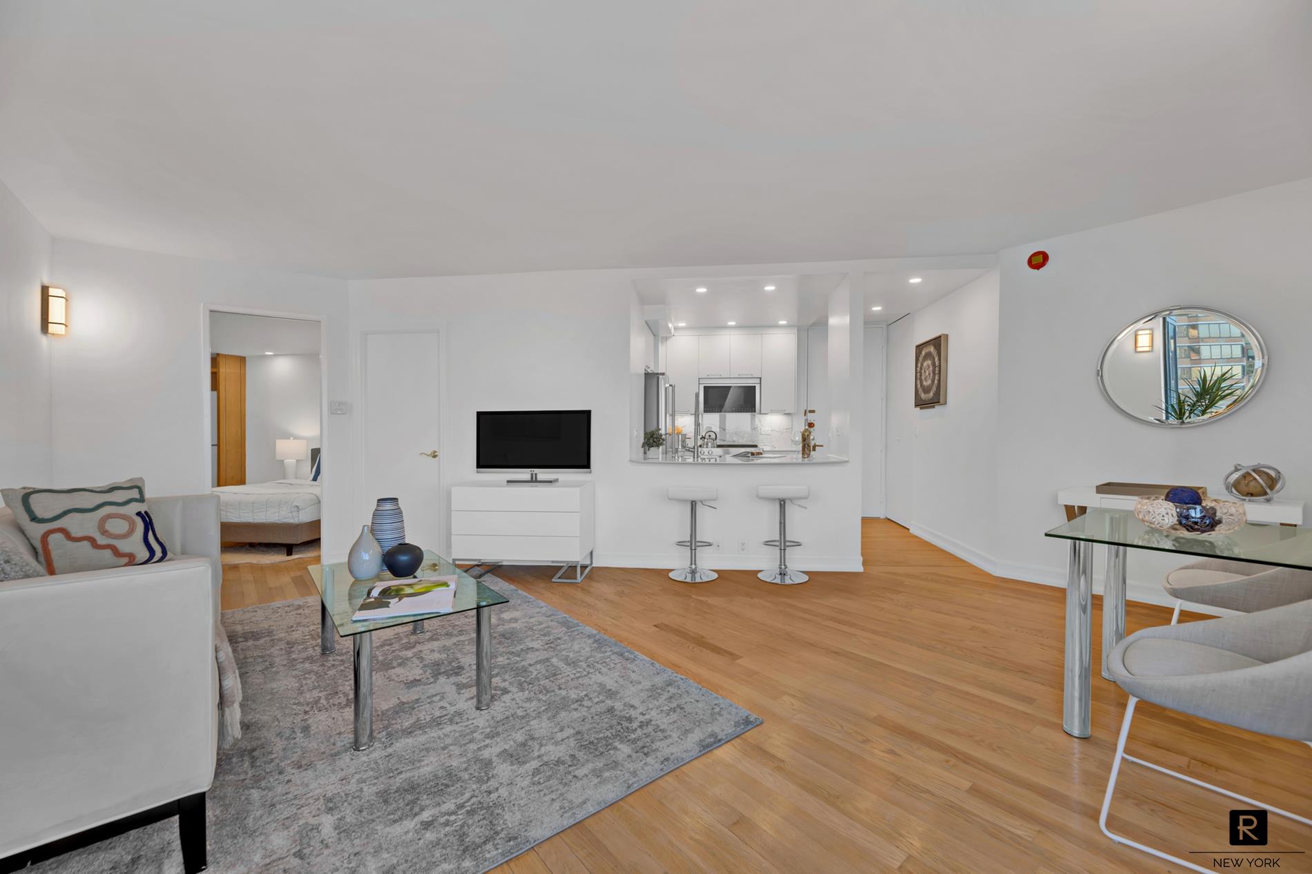 415 East 37th Street, Unit 27D Manhattan, NY 10016 - Photo 3 of 17 a living room with furniture and flat screen tv