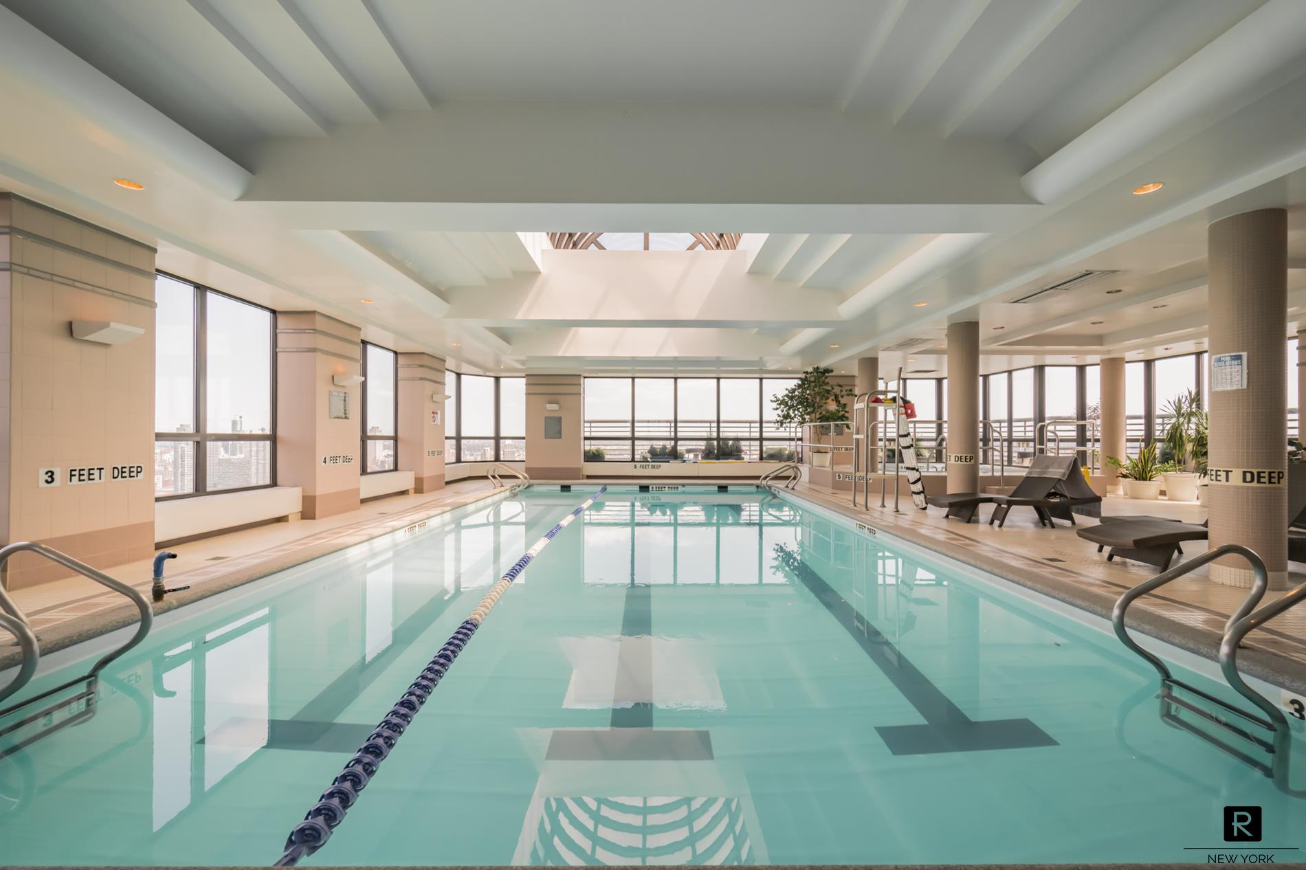 415 East 37th Street, Unit 27D Manhattan, NY 10016 - Photo 7 of 17 a large white kitchen with kitchen island lots of counter space a sink and a large window