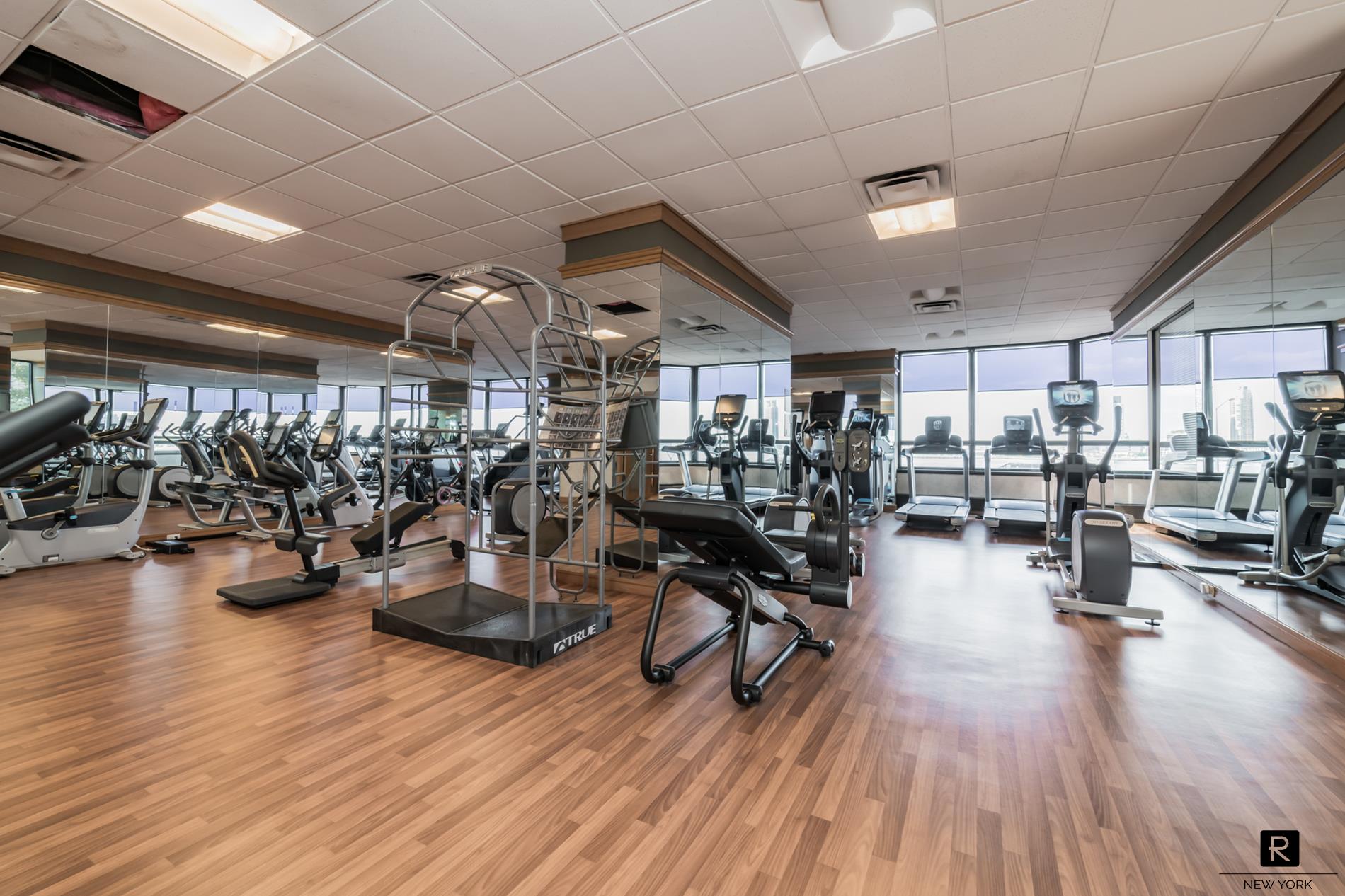 415 East 37th Street, Unit 27D Manhattan, NY 10016 - Photo 10 of 17 a view of a room with lots of wooden furniture and windows