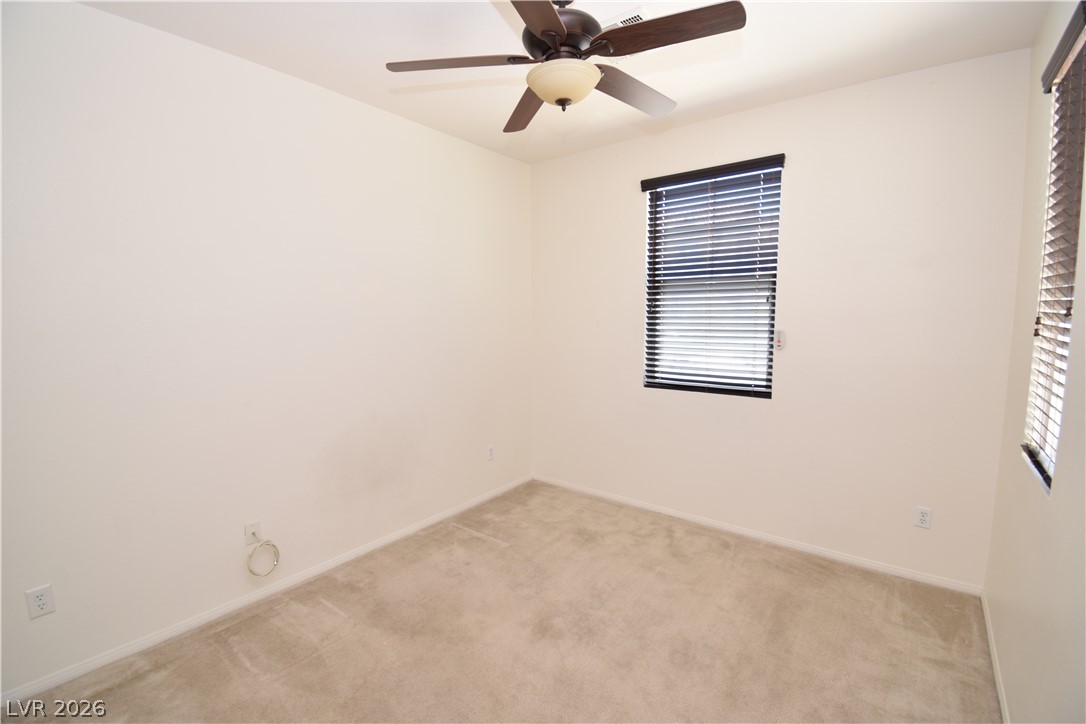 3622 Via Terracina Henderson, NV 89052 - Photo 9 of 22 A well-lit bedroom features plush carpet and a stylish ceiling fan with integrated lighting.