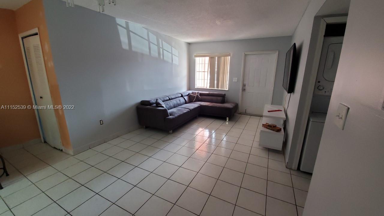 5830 West 18th Lane, Unit 101 Hialeah, FL 33012 - Photo 3 of 14 a living room with furniture and a gate