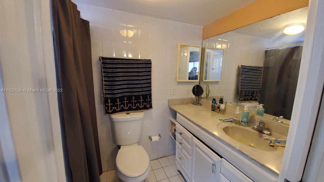 5830 West 18th Lane, Unit 101 Hialeah, FL 33012 - Photo 10 of 14 a bathroom with a granite countertop sink toilet and shower