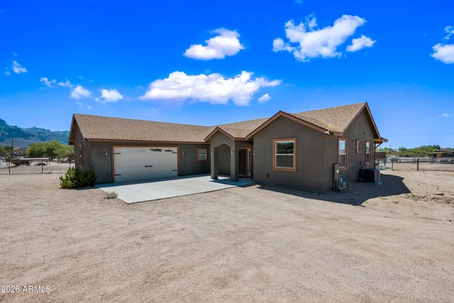 a living room with furniture kitchen view and a wooden floor