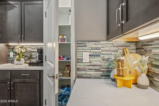 a bedroom with a bed and dresser with wooden floor