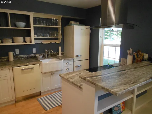 a kitchen with granite countertop a sink stove and refrigerator