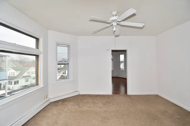 an empty room with fan and windows
