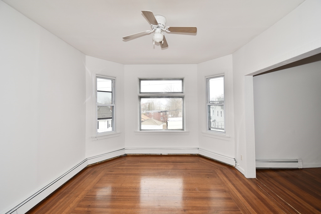 86 Cochran Street, Unit 3 Chicopee, MA 01020 - Photo 5 of 18 a view of an empty room with a window and wooden floor