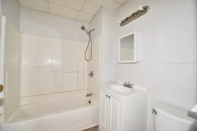 a white bath tub sitting next to a white sink and a shower