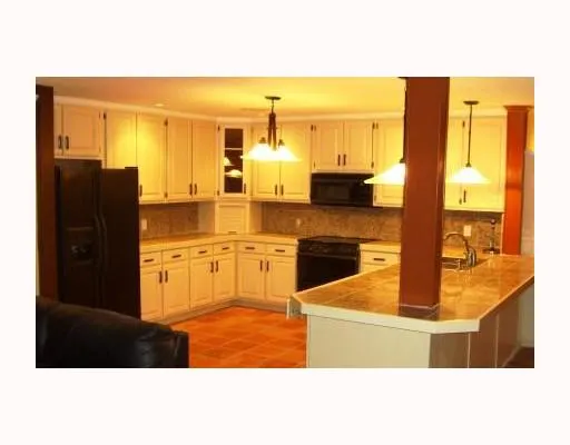a kitchen with stainless steel appliances kitchen island granite countertop a refrigerator and cabinets