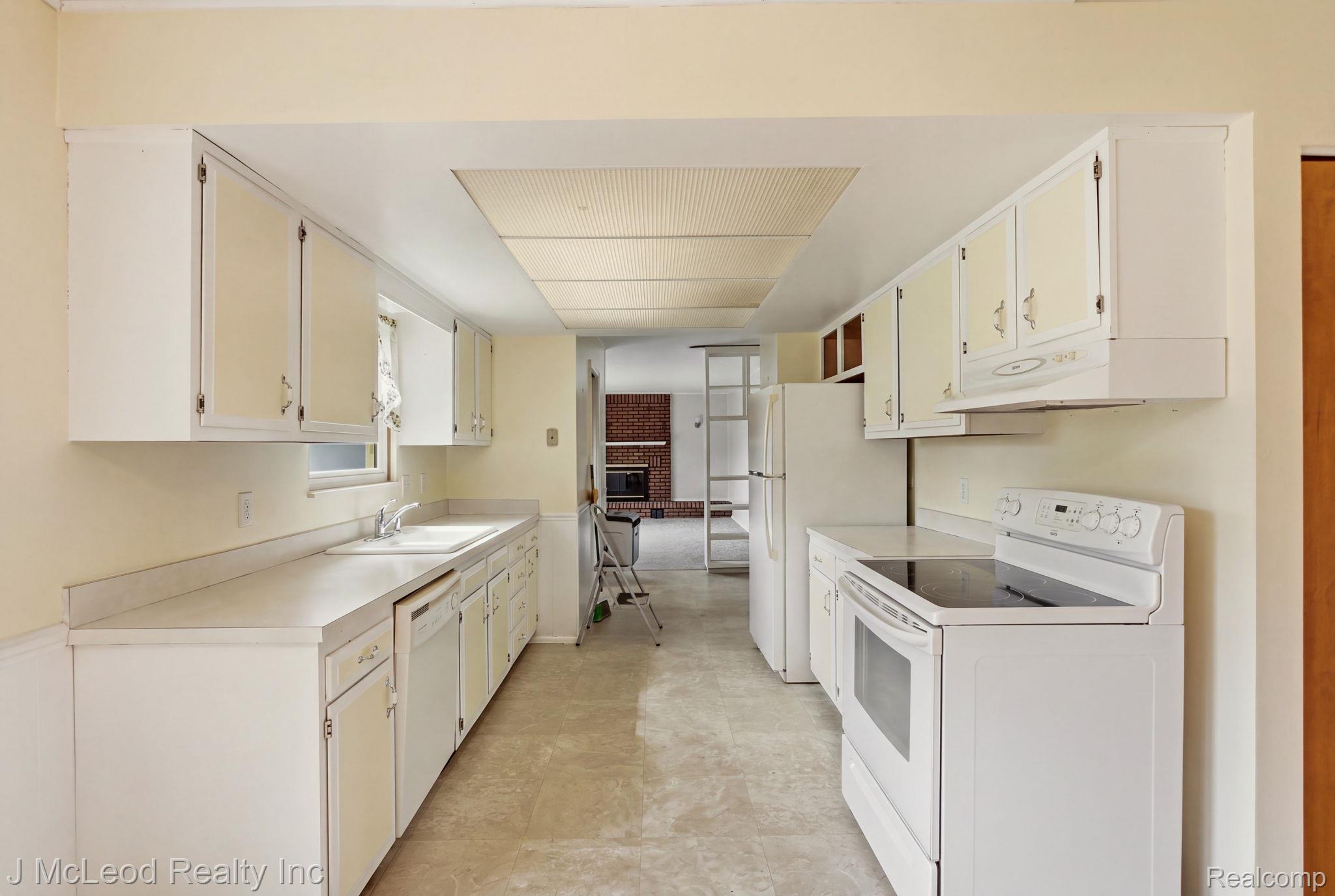 9481 Swaffer Road Vassar, MI 48768 - Photo 12 of 39 Galley kitchen featuring a window over the sink, white cabinetry, a built-in dishwasher, and an electric range with an overhead exhaust fan