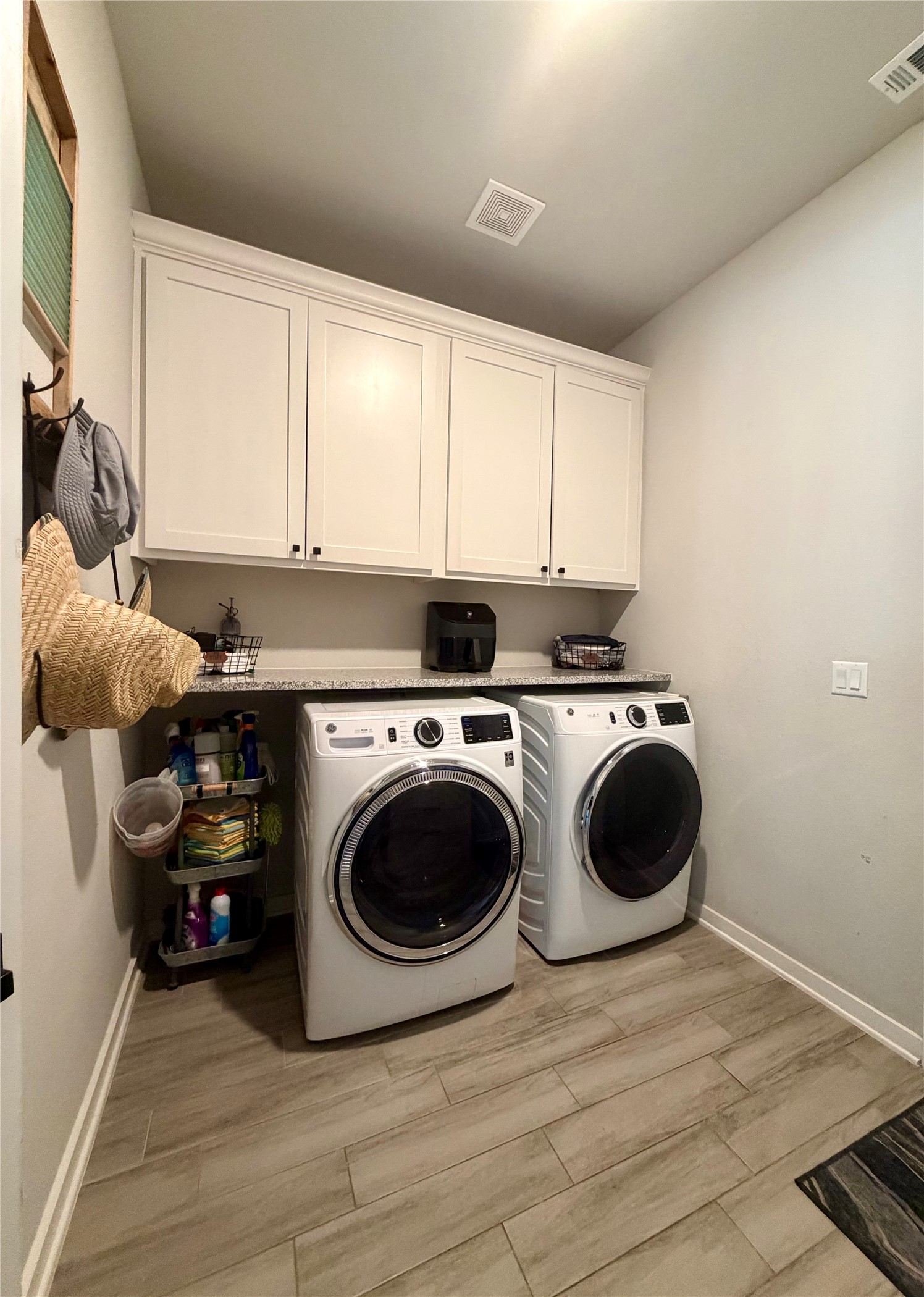 14302 Summit View Drive, Unit 4 Leander, TX 78641 - Photo 22 of 40 Laundry area featuring wood finish floors, washer and clothes dryer, and cabinet space