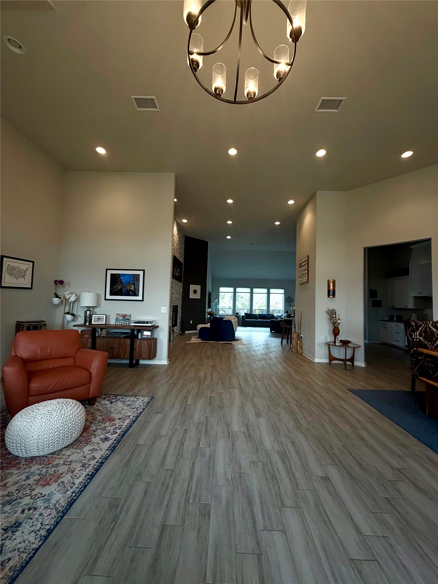 14302 Summit View Drive, Unit 4 Leander, TX 78641 - Photo 3 of 40 Living room featuring wood finished floors, a high ceiling, and a chandelier