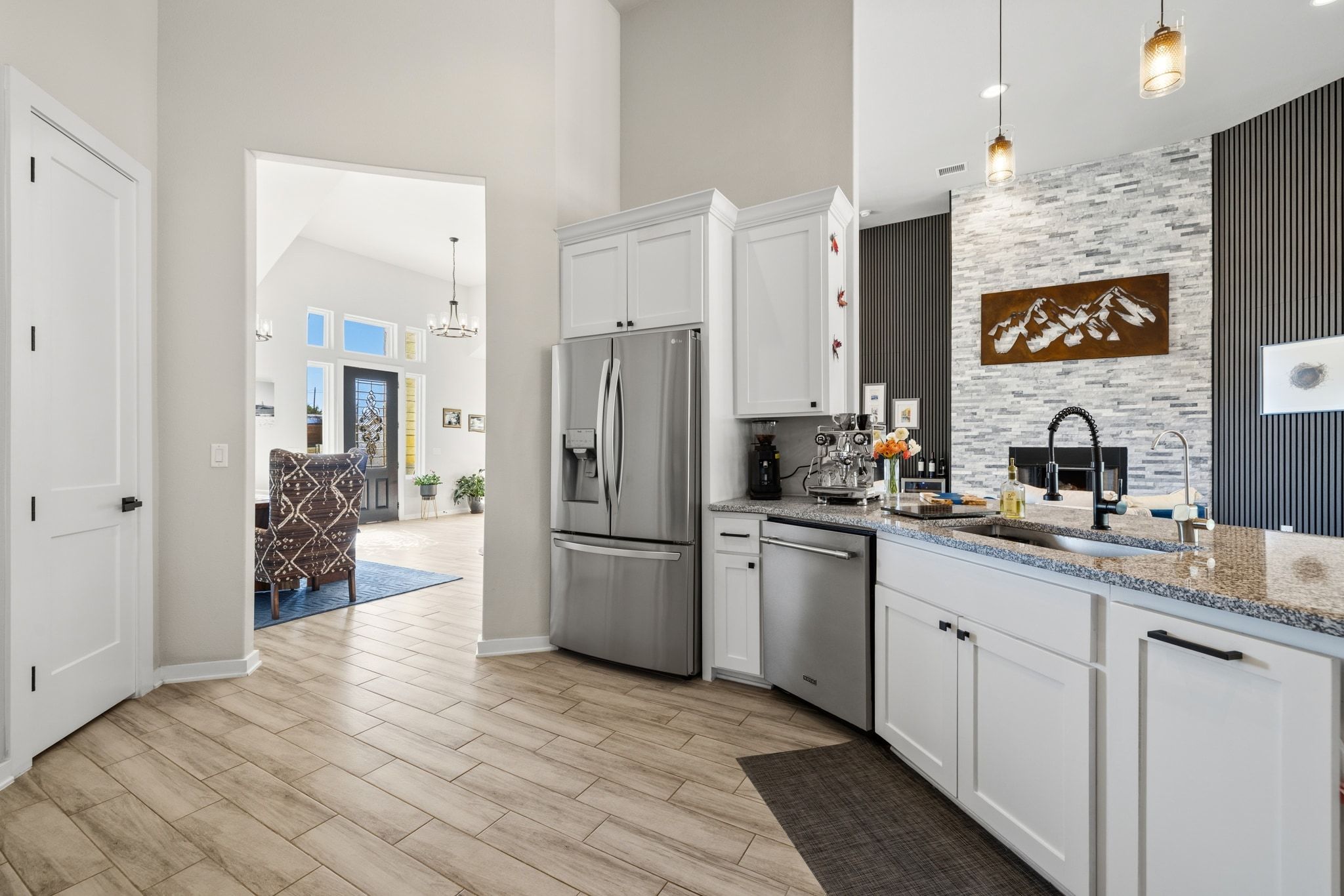 14302 Summit View Drive, Unit 4 Leander, TX 78641 - Photo 7 of 40 Kitchen featuring white cabinets, light stone counters, stainless steel appliances, wood tiled floors, and hanging lights