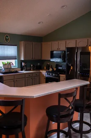 a kitchen with a table chairs microwave and cabinets