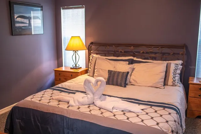 a bedroom with a bed and a lamp on dresser