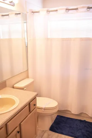 a bathroom with a sink a toilet and a window