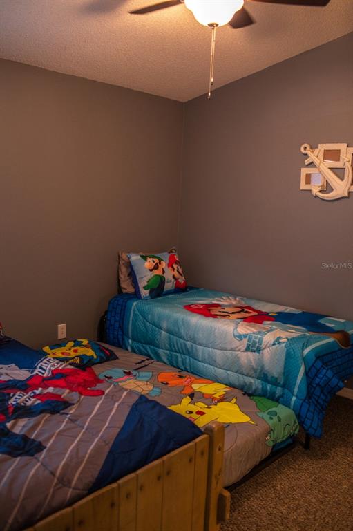 2577 Oneida Loop Kissimmee, FL 34747 - Photo 30 of 36 a bedroom with a bed and a small yard