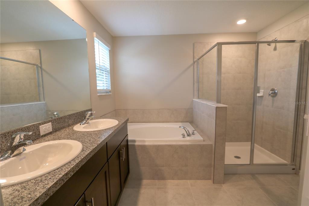 4714 Norman Oak Place Tampa, FL 33619 - Photo 11 of 32 a bathroom with a granite countertop sink a mirror and a bathtub