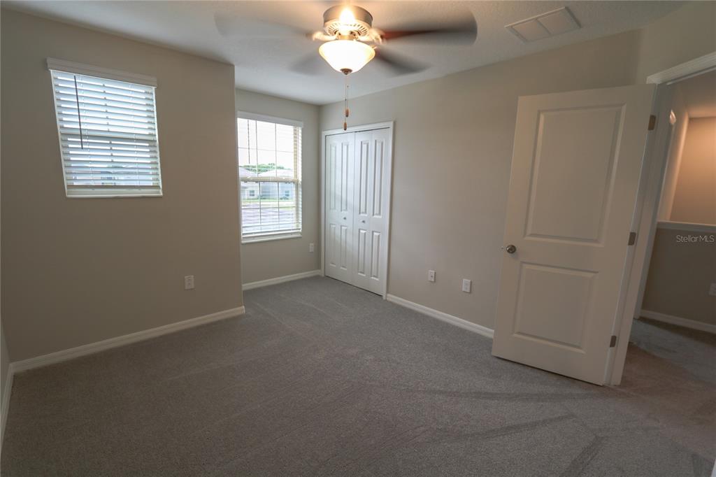 4714 Norman Oak Place Tampa, FL 33619 - Photo 16 of 32 an empty room with windows and chandelier fan