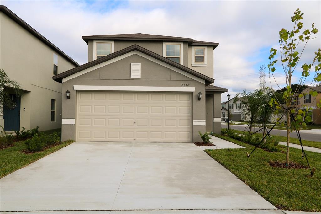 4714 Norman Oak Place Tampa, FL 33619 - Photo 2 of 32 a front view of a house with a yard and garage